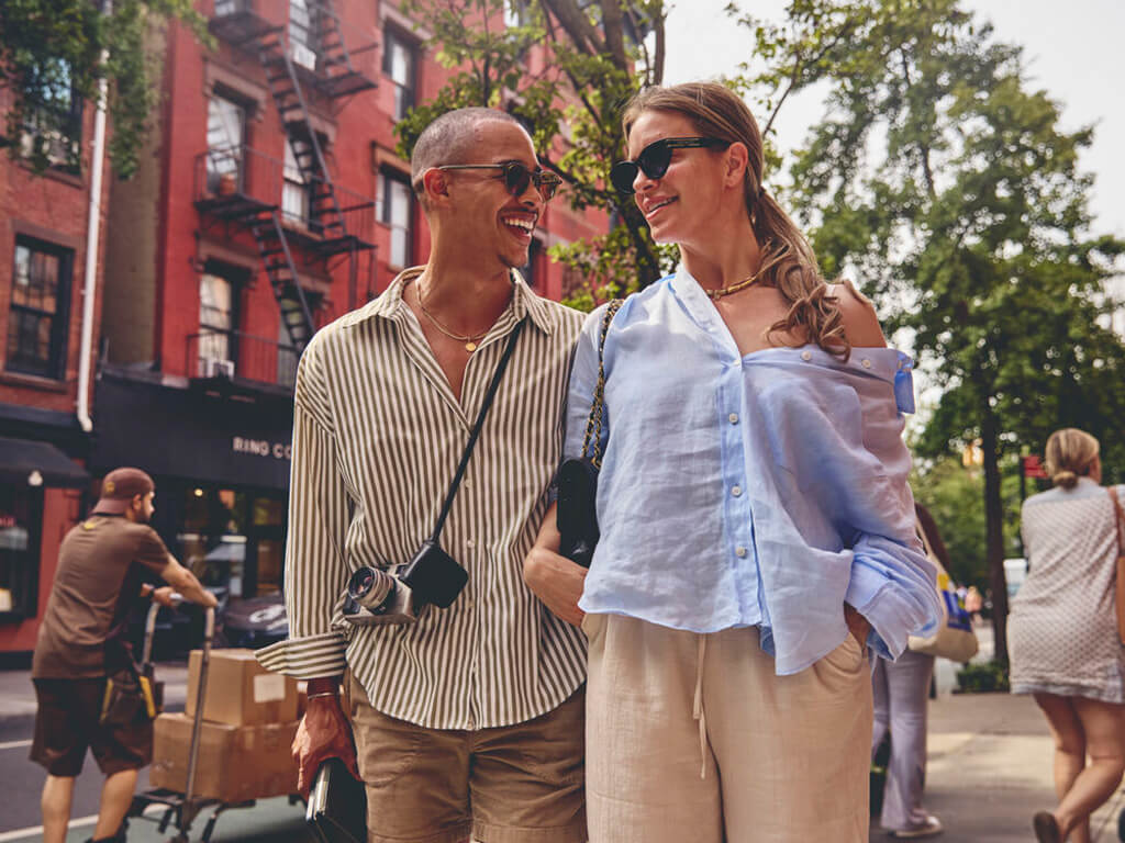 Man and woman laugh as they walk through New York together