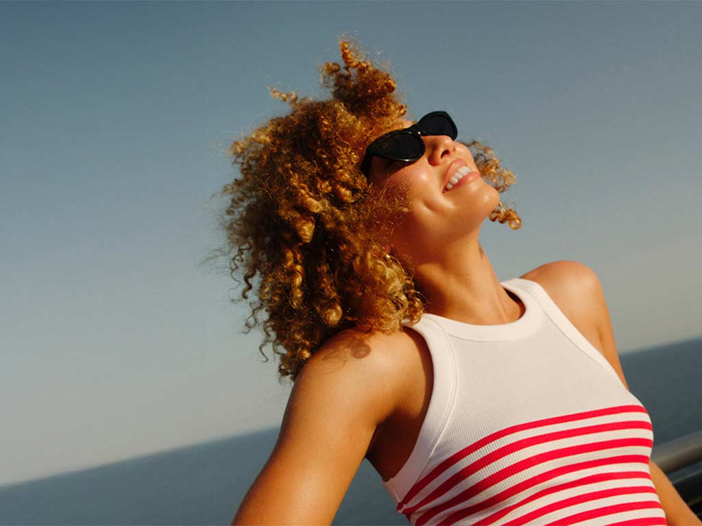 Lady in sunglasses with a white and red stripe top