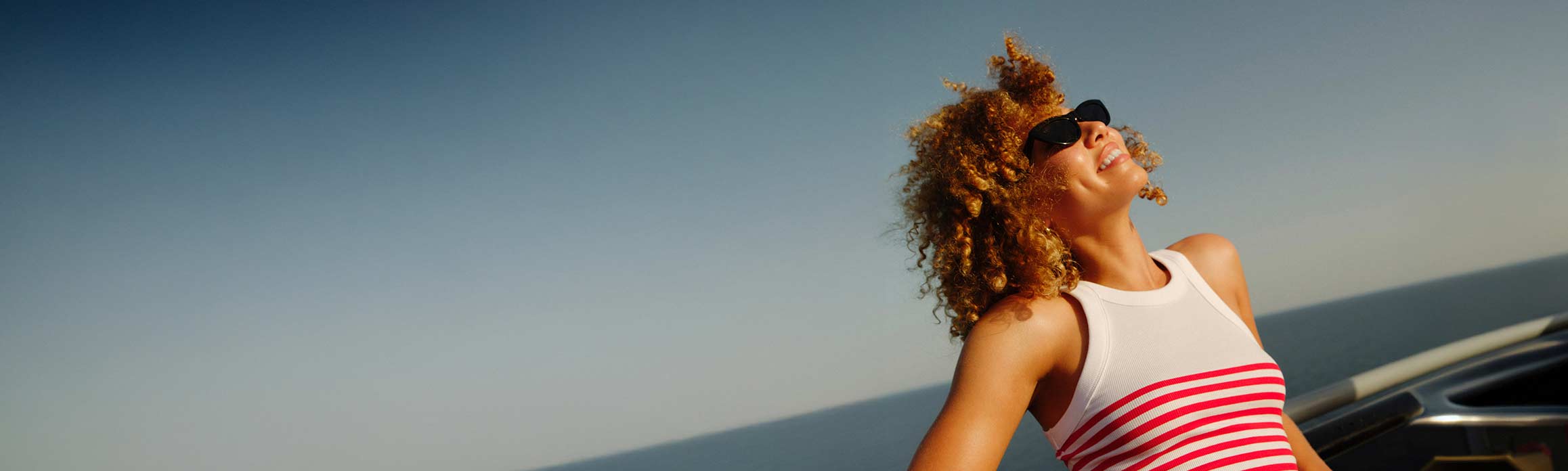 Lady in sunglasses with a white and red stripe top