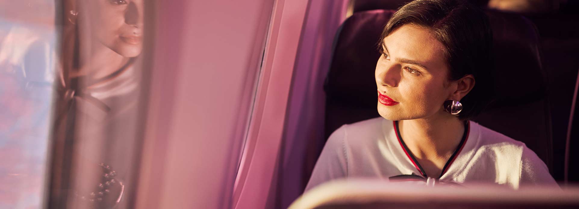 A lady onboard an sircraft looking out of the window