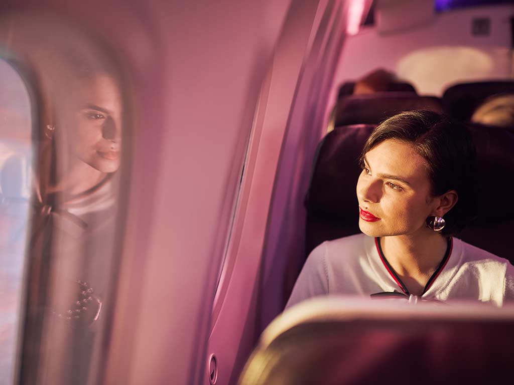A lady onboard an sircraft looking out of the window