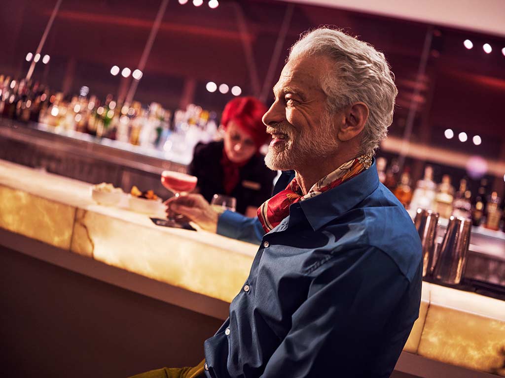 Man having a drink at the Clubhouse at Heathrow