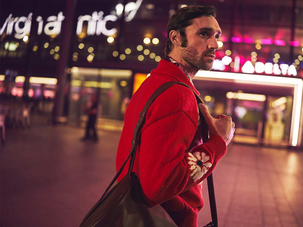 Man in a red jumper walking into Terminal 3 at Heathrow