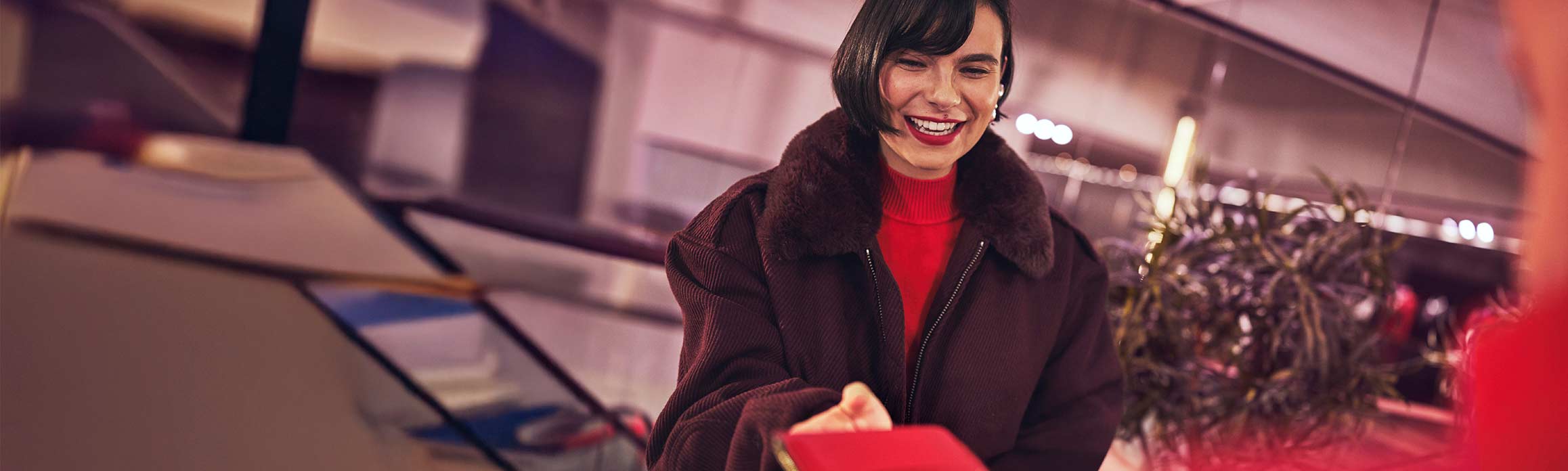 Lady checking in for her flight in a brown jacket