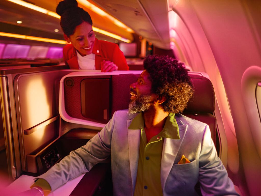 Man in Upper Class seat with Cabin Crew