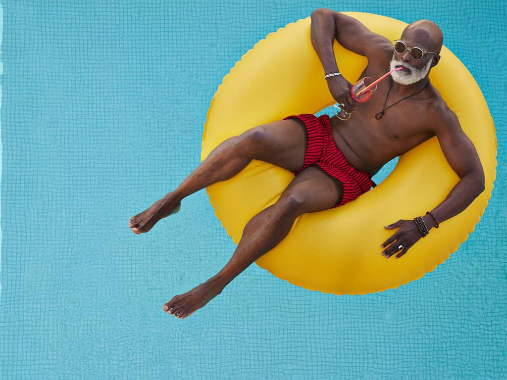 Man in yellow rubber ring floating in pool