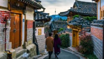 A couple walk down an alley beside a temple in Seoul, South Korea