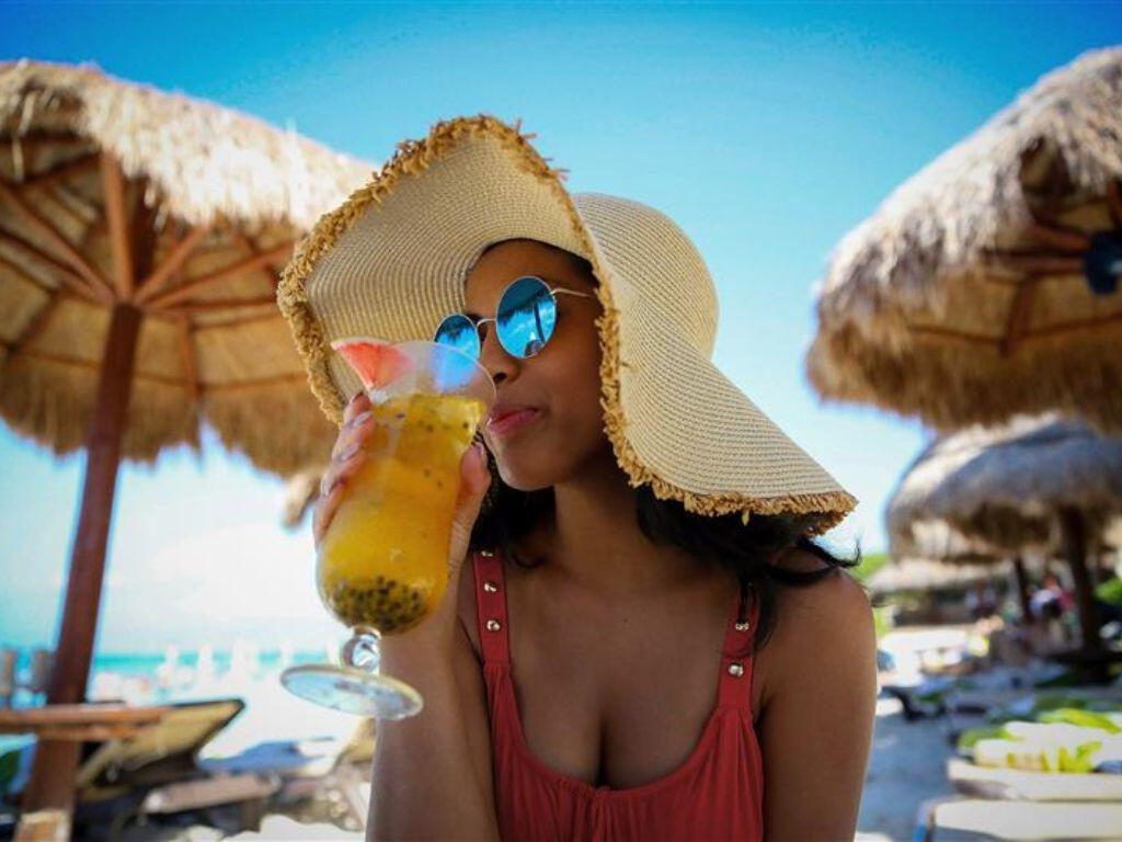 Lady sipping a cocktail on the beach