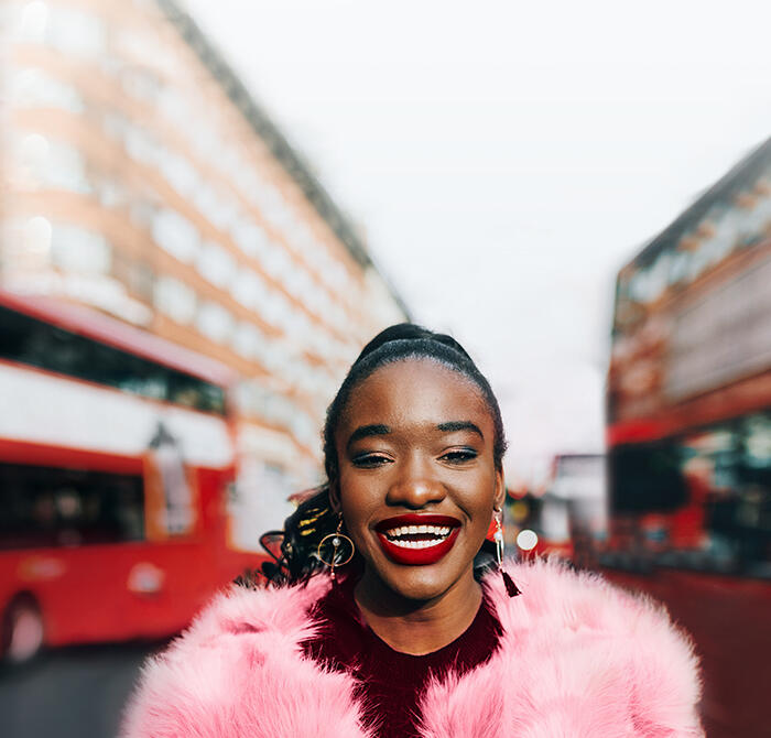 Lady stands next to London bus