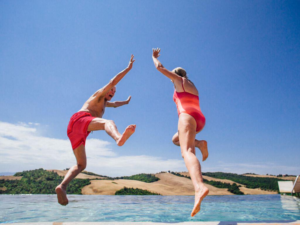 Couple jumping in the pool