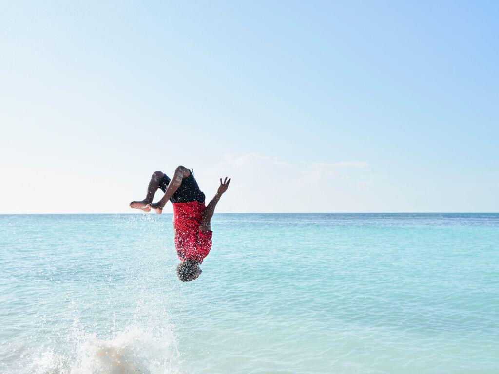Man backflipping into the sea