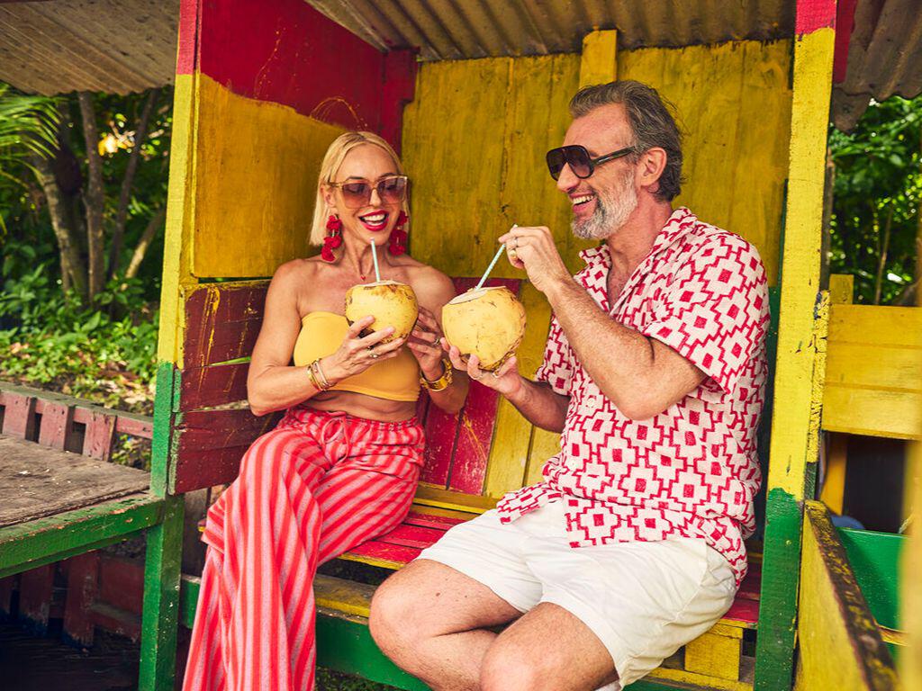 Couple having cocktails in a Caribbean bus shelter
