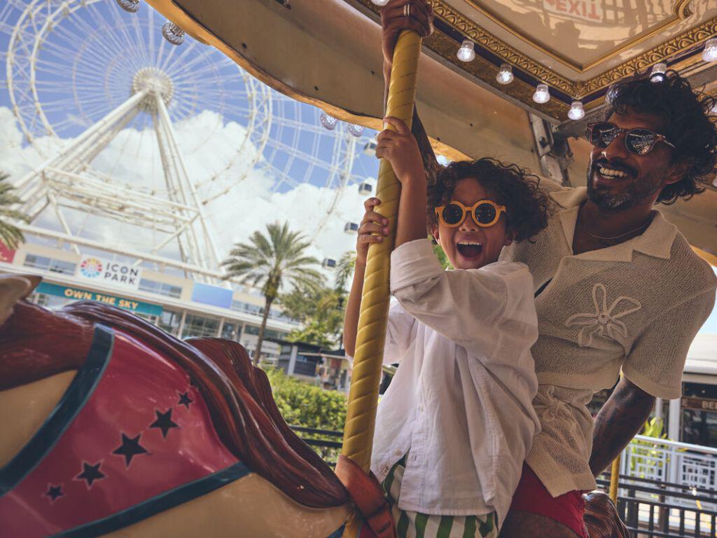 Boy and dad on ride with Orlando Eye in the background