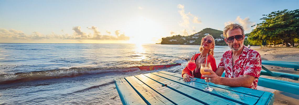Couple on beach drinking cocktails