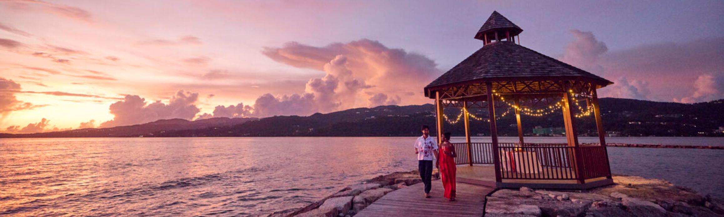 Couple walking from a private dinner table at sunset