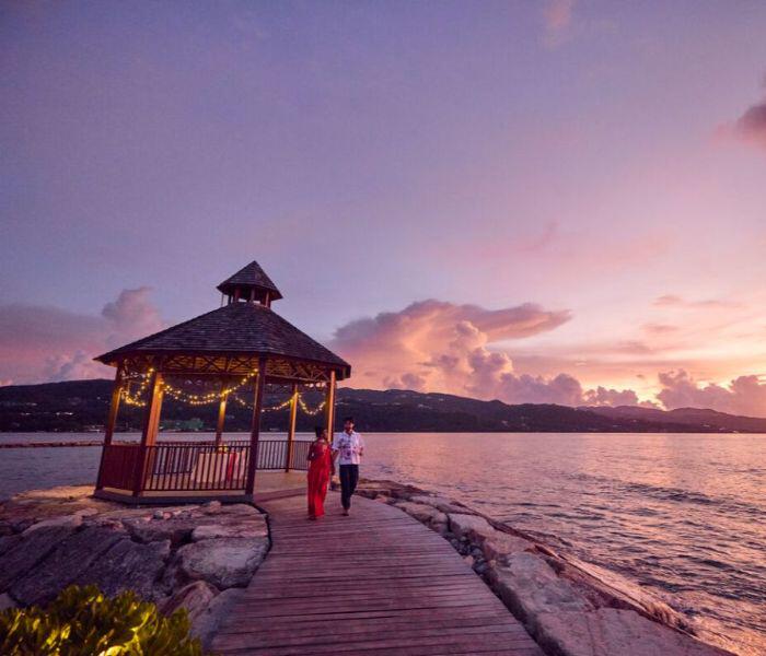 Couple walking from a private dinner table at sunset