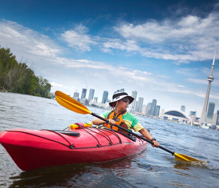 Man kayaking with Toronto city background