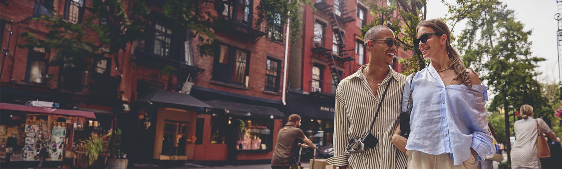 Man and woman laugh as they walk through New York together