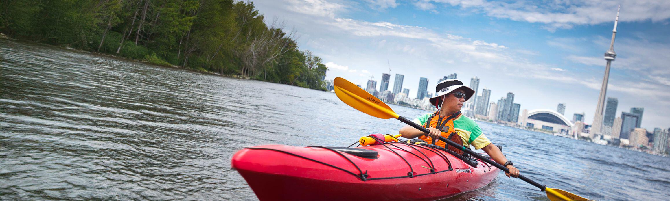 Man kayaking with Toronto city as the background