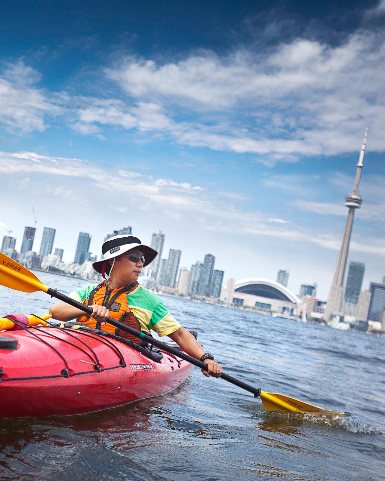 Man kayaking with Toronto city background