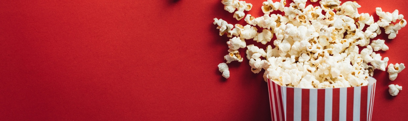 Red and white striped carton with popcorn overflowing