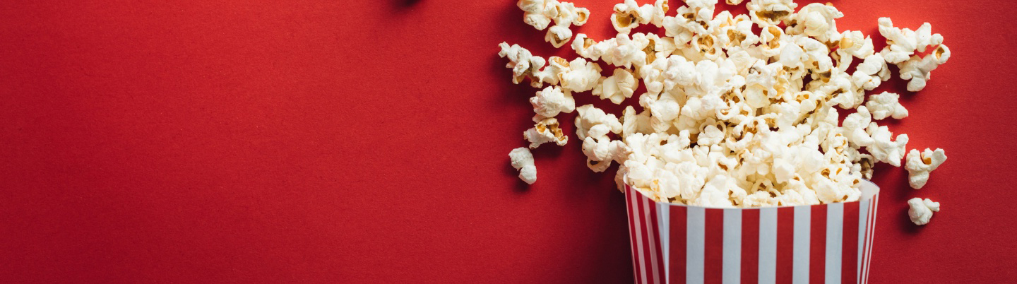 Red and white striped carton with popcorn overflowing