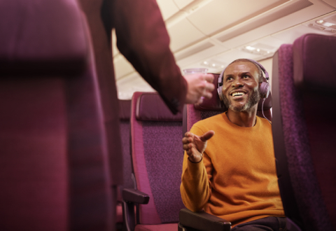 Man in orange jumper in economy seat