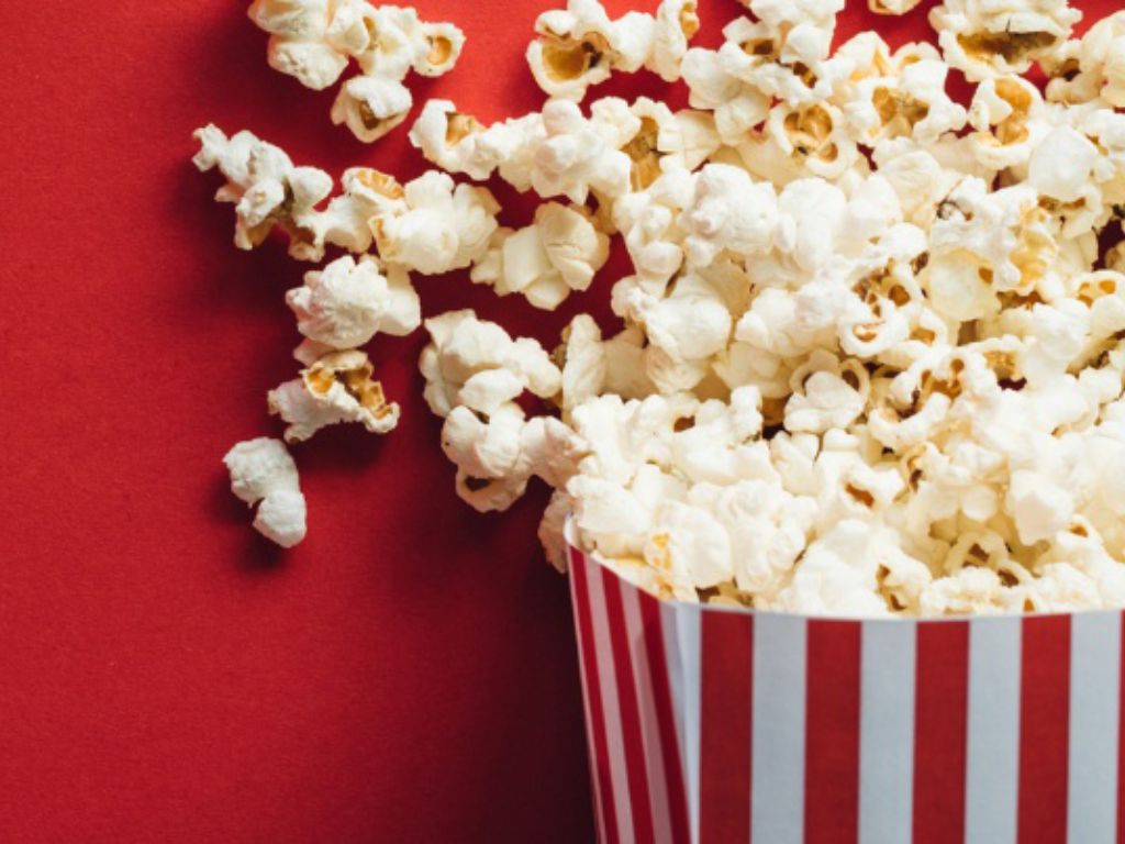 Red and white striped carton with popcorn overflowing