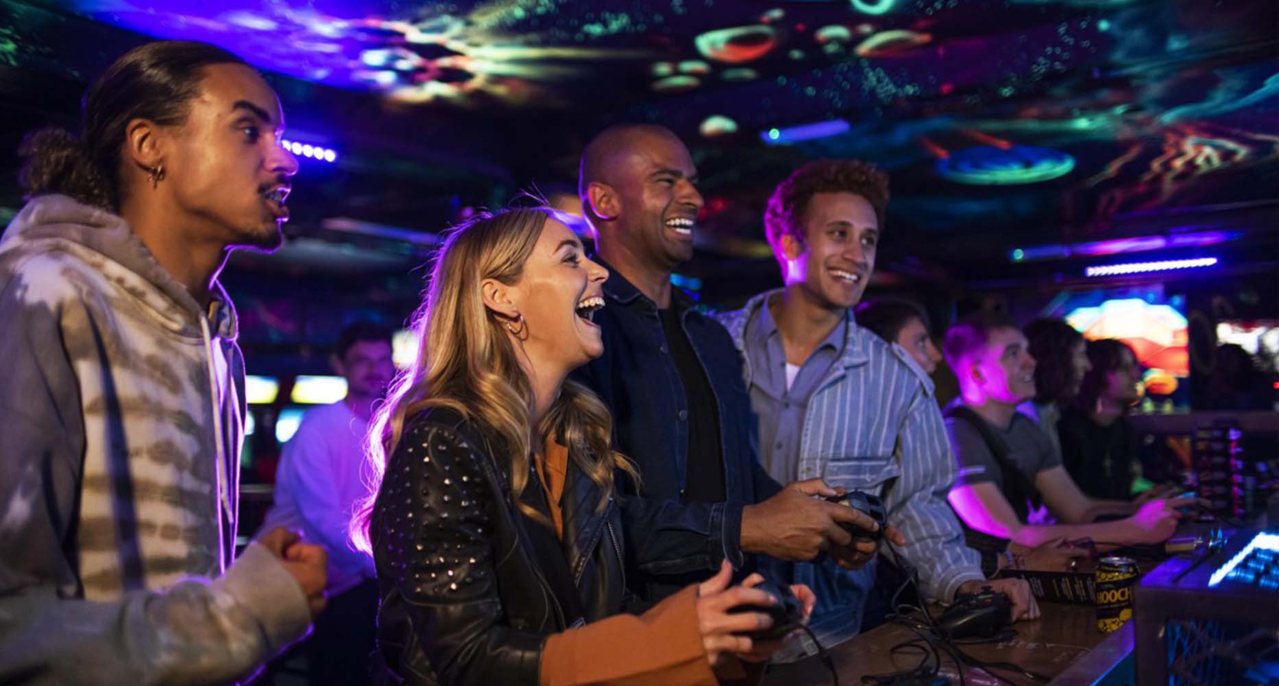 A group of friends play a game together in an arcade