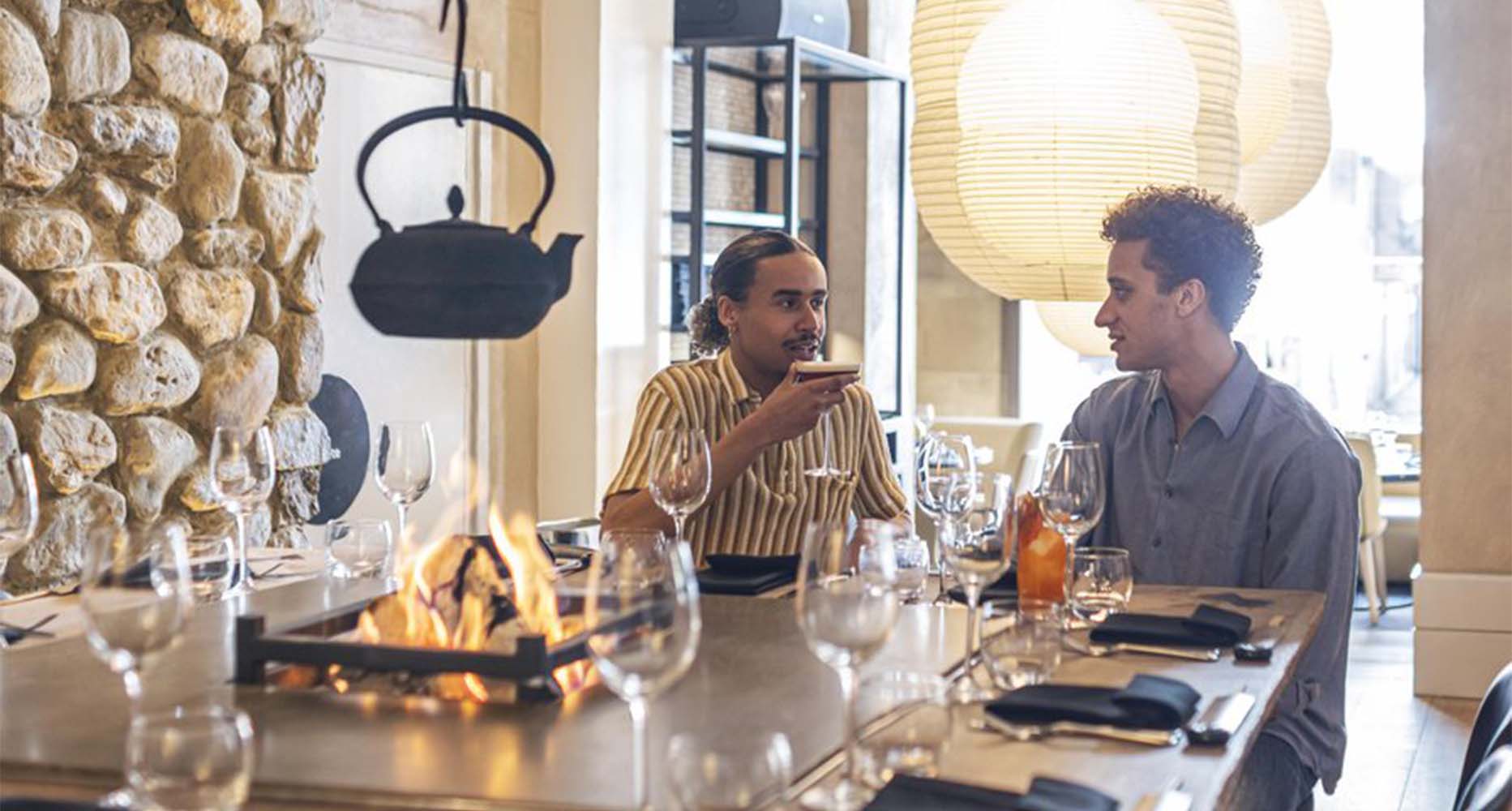 Two people sit in a restaurant sipping cocktails