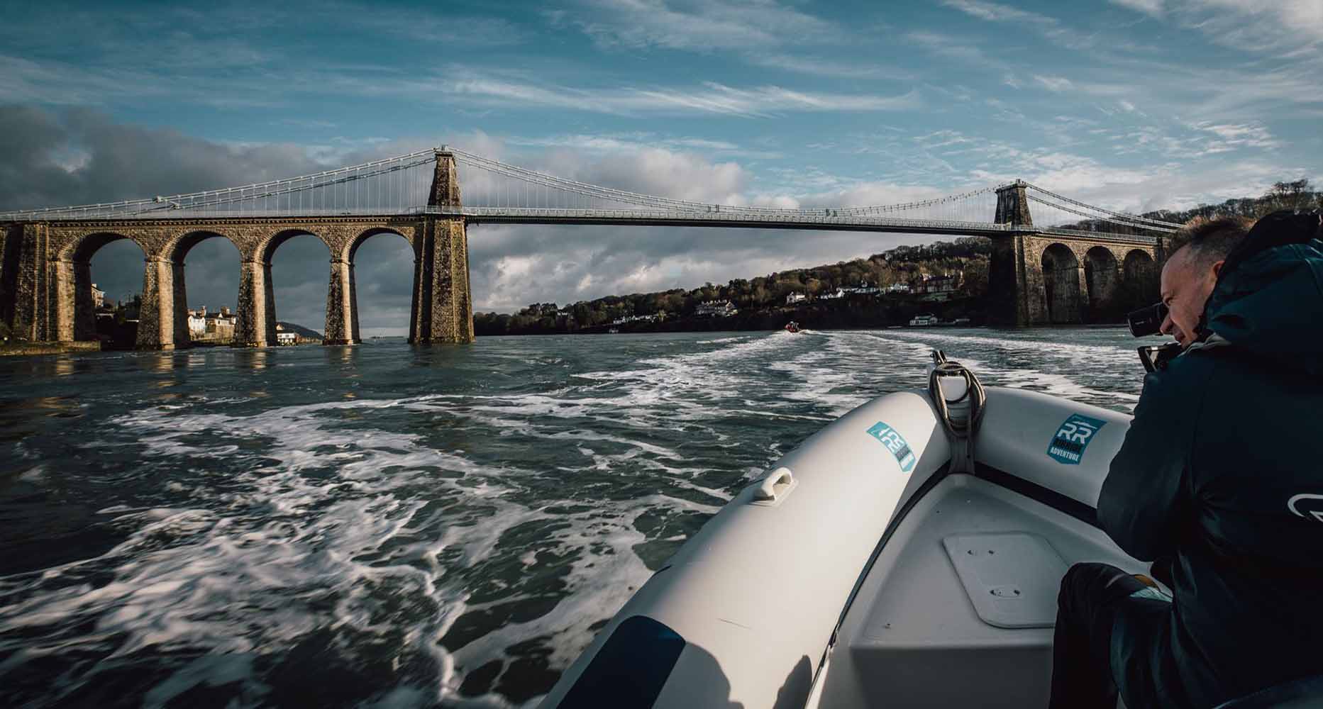 A boat journeys along the Menai Strait