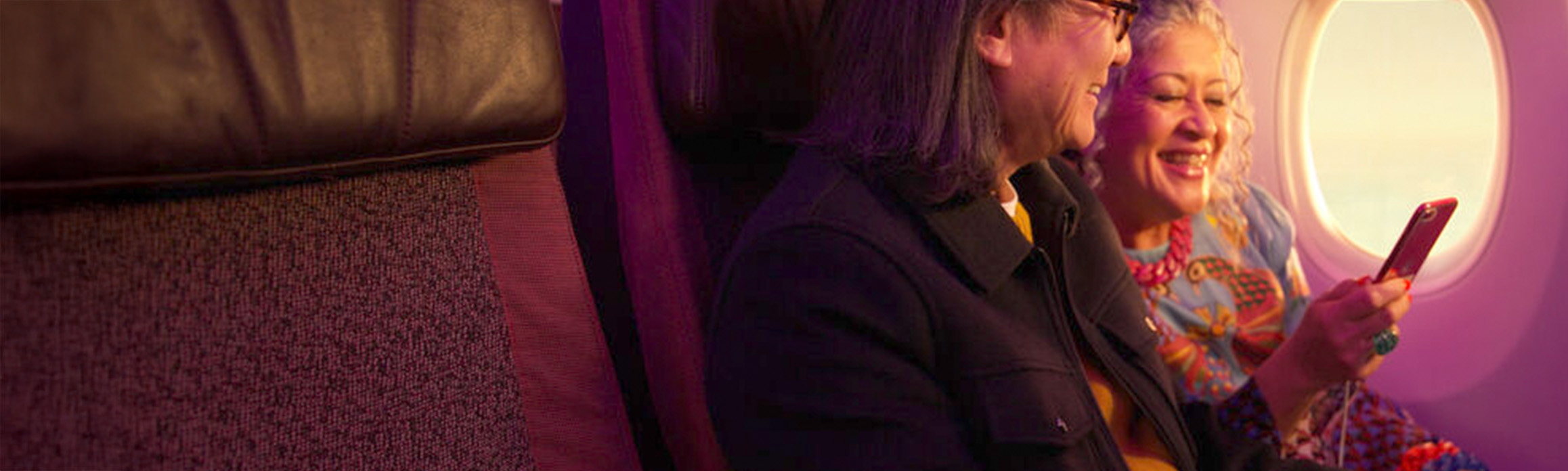Couple in Economy looking at their phone