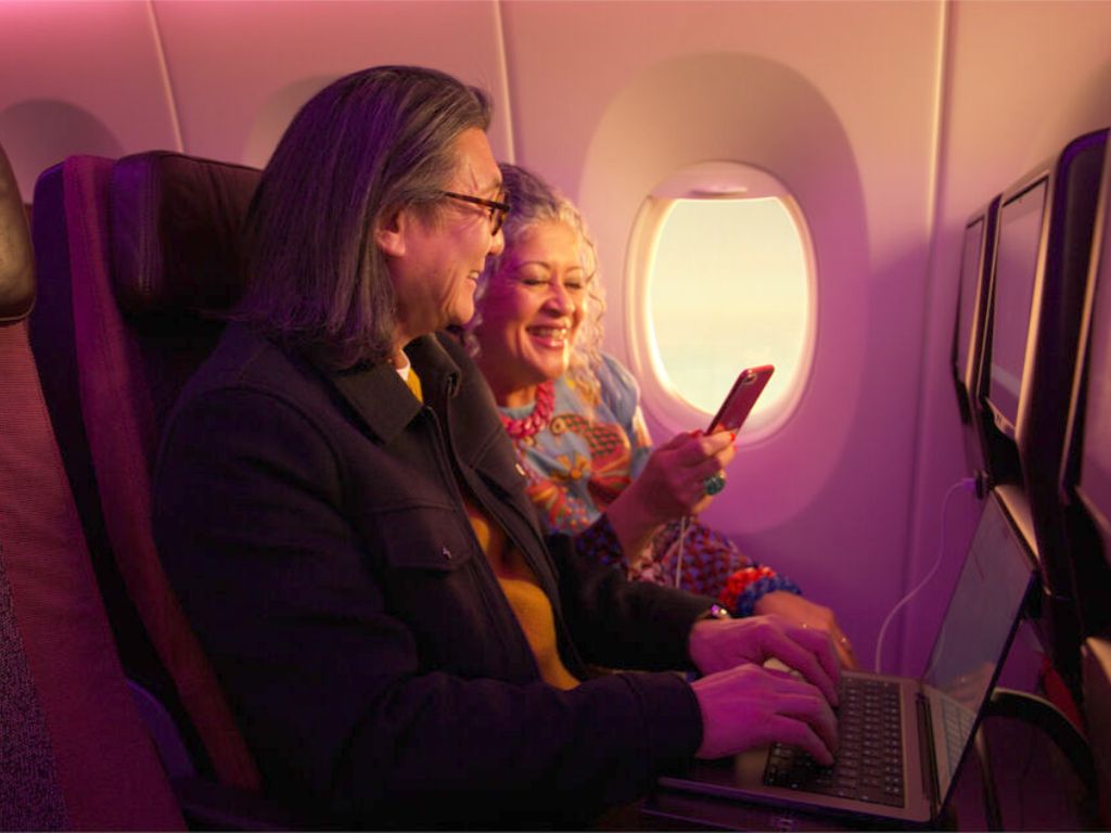 Couple in Economy looking at their phone