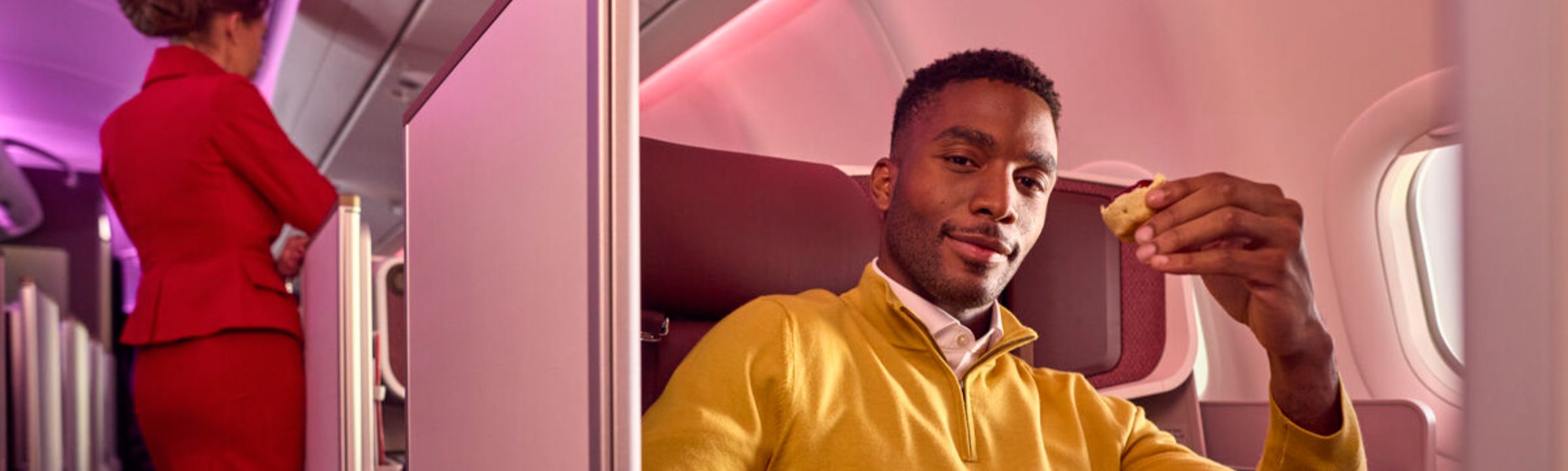 Man in yellow jumper in Upper Class seat