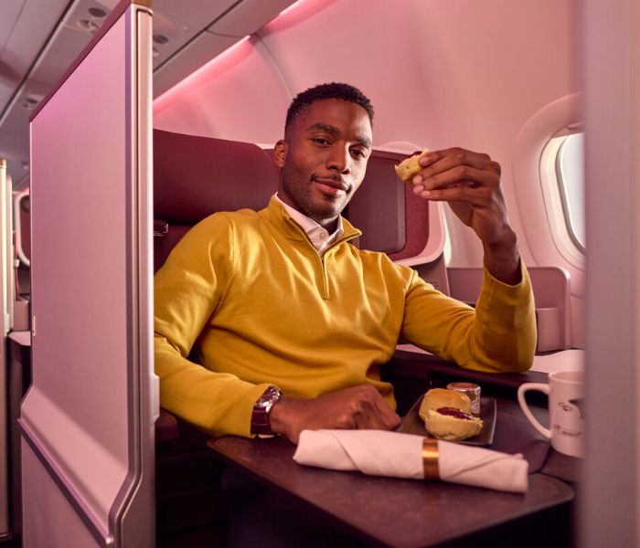 Man in yellow jumper in Upper Class seat