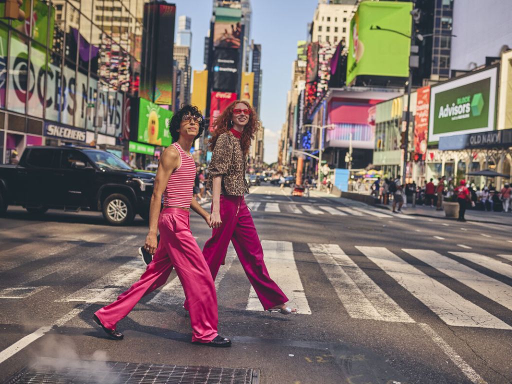Couple walking through Times Square holiding hands