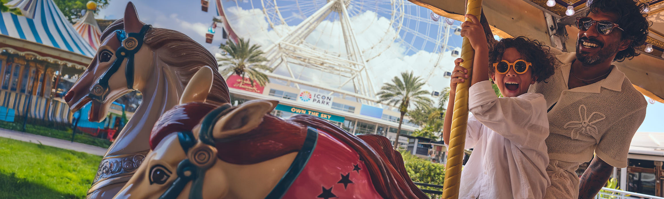 Father and son on a carousel with the ICON wheel in the background