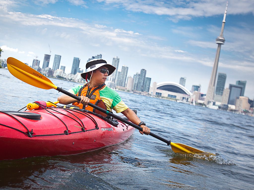 Man kayaking with Toronto city background
