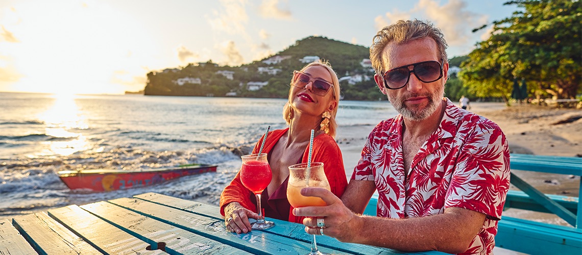 Couple on beach drinking cocktails