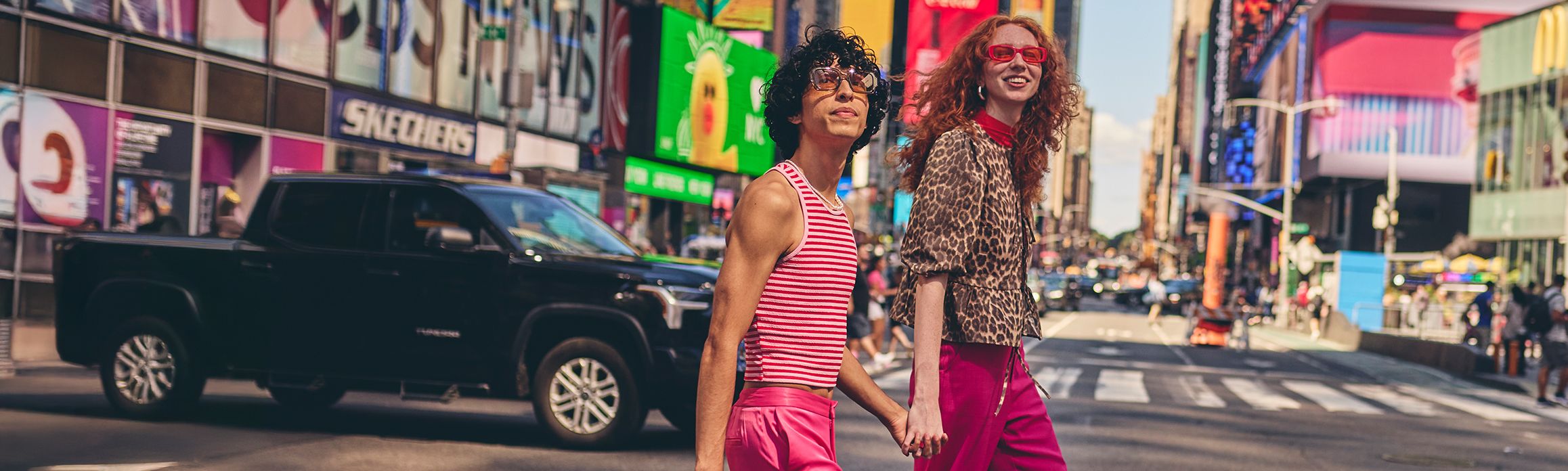 Couple walking through Times Square holiding hands