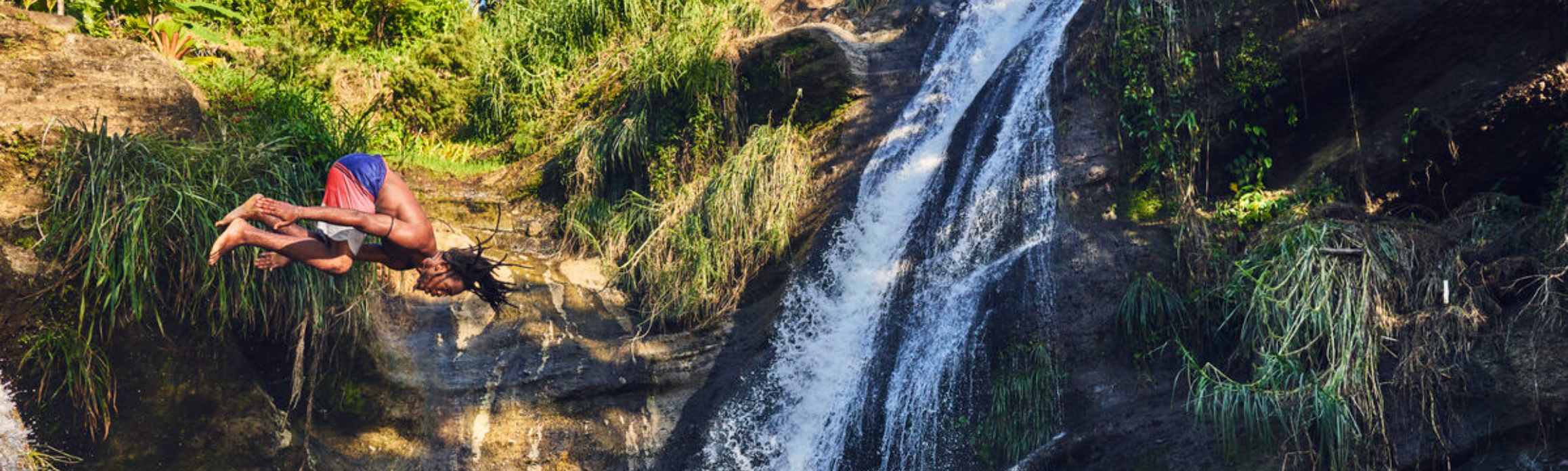 Man jumping into a waterfall in the Caribbean