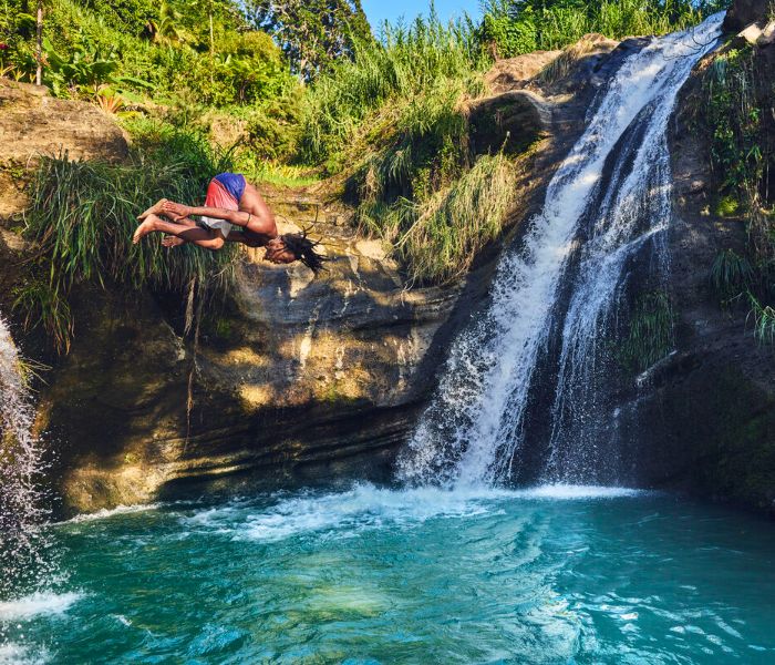 Man jumping into a waterfall in the Caribbean