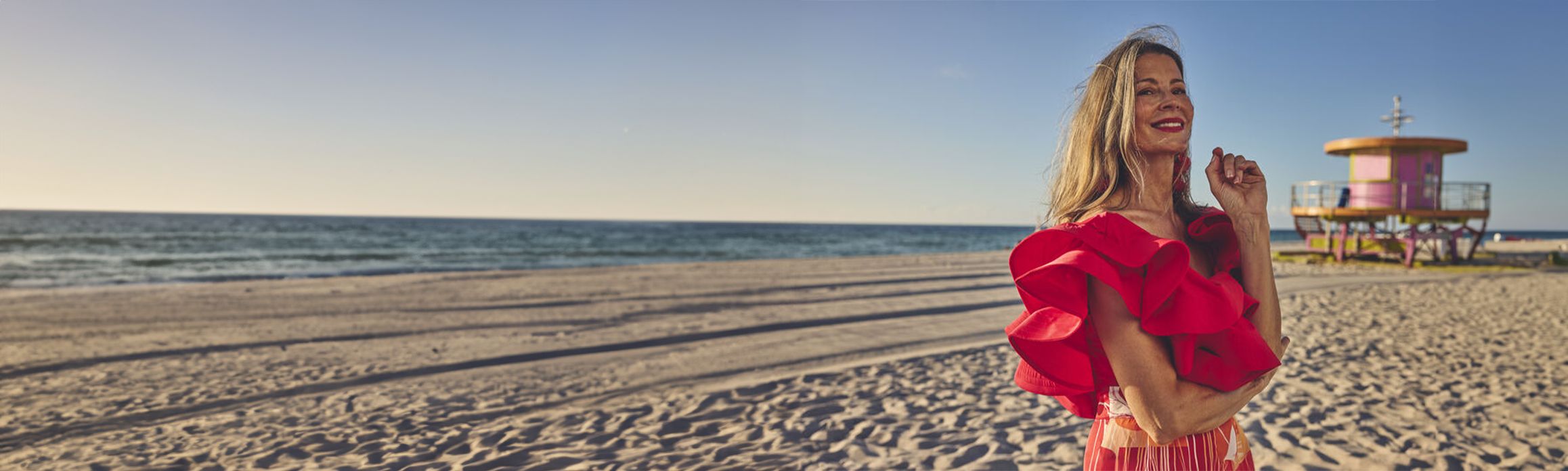 Woman on Miami beach with lifeguard tower in background