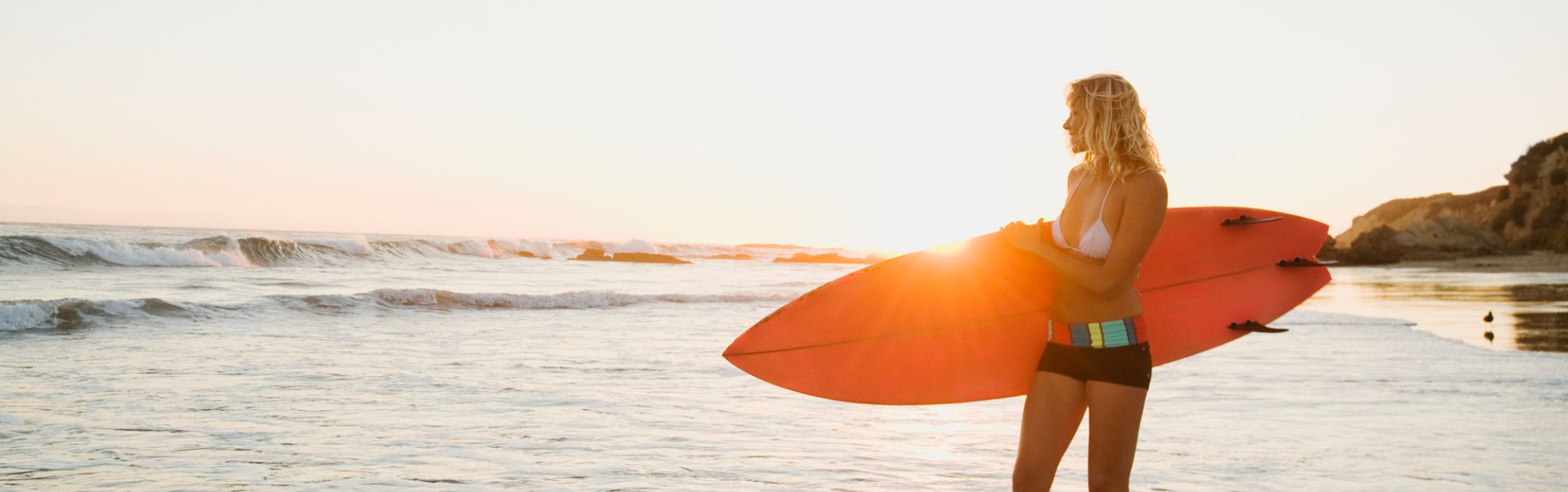 Woman with surfboard on Newport Beach